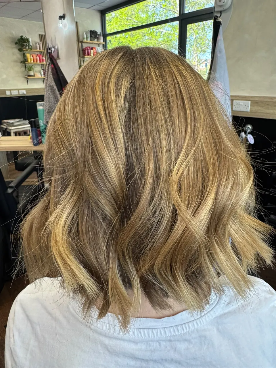 Long bob with honey-toned highlights and soft waves, cut in Horsham